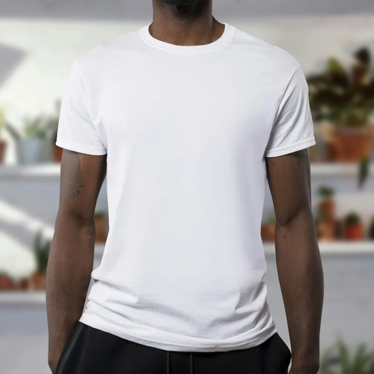 Detalle de una remera blanca lisa usada por un modelo.